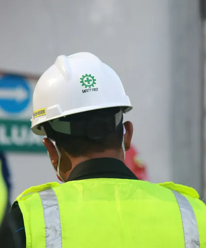 Servicios de seguridad industrial: supervisor con casco y chaleco en campo